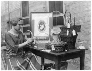 Woman placing tags on baskets, 1925