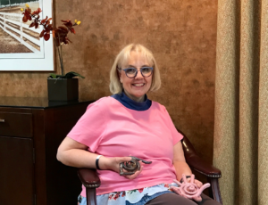 Linda holding two hand-sized coil clay sculptures