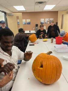 Students and instructors surrounding the pumpkin carving table