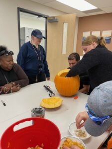 Jose getting help from Instructor Lauren carving the pumpkin